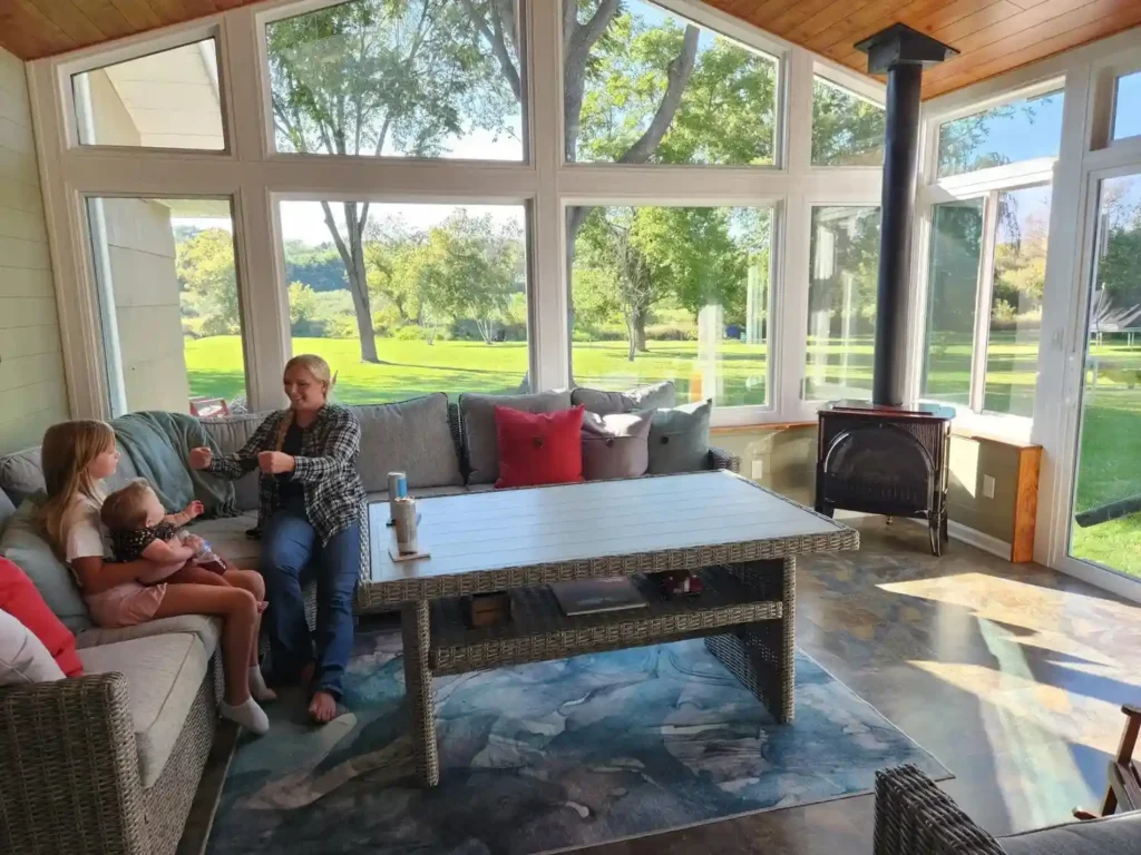 A person relaxing in a bright, sunlit sunroom.